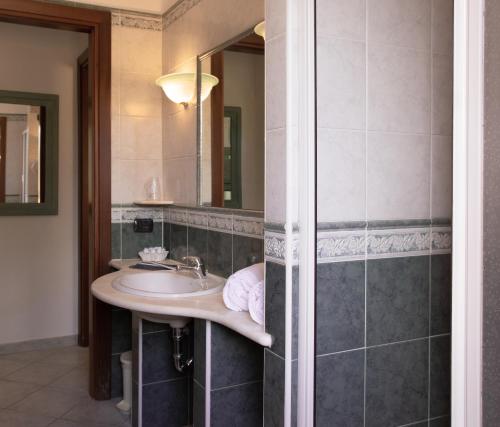 a bathroom with a sink and a mirror at Residence Cala Viola in Cala Liberotto