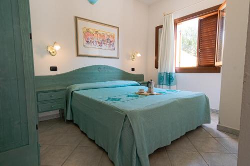 a bedroom with two beds and a window at Residence Cala Viola in Cala Liberotto