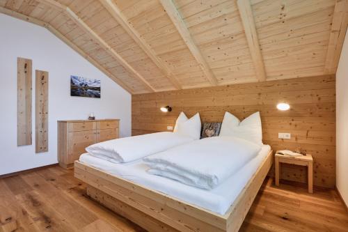 a bedroom with a large bed in a wooden ceiling at Huberhof in San Lorenzo di Sebato