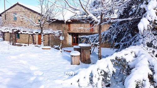 a house in the snow with two logs at Cascina Boschetto in Saliceto