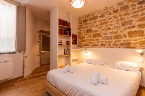 a bedroom with a large white bed with towels on it at DIFY Chardonnay - Bellecour in Lyon