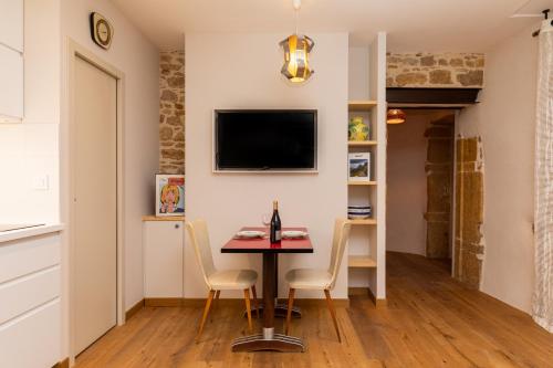 une salle à manger avec une table et des chaises et une télévision dans l'établissement DIFY Chardonnay - Bellecour, à Lyon