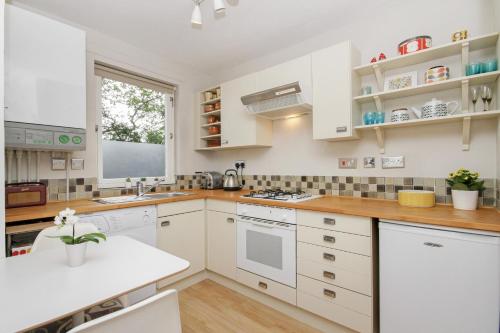 Una cocina con gabinetes blancos y encimera. en City Centre Haven Apartments, en Edimburgo