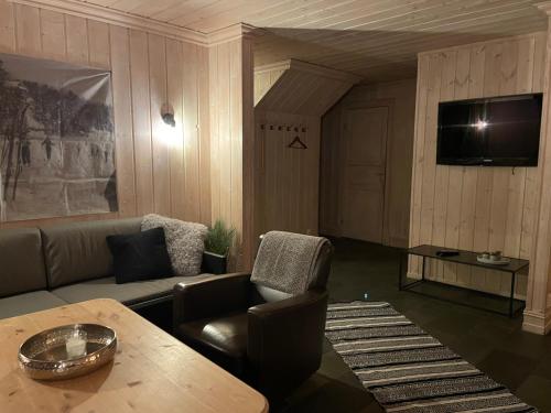 a living room with a couch and a table at Tinden in Hemsedal
