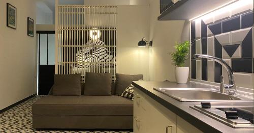 a kitchen with a couch and a zebra on the wall at Sunrise Estudio Zebra, con vistas jardín y mar in Miami Platja