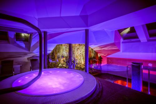 a bath tub in a room with purple lighting at Theresian Hotel in Olomouc