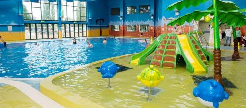 a swimming pool with a slide in the water at Lovely Static Caravan at Billing Aquadrome in Great Billing