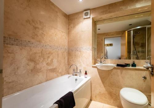 een badkamer met een bad, een toilet en een wastafel bij Lux Duplex Apartment 19th Century Chapel Wakefield Centre in Wakefield
