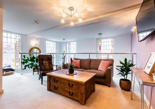 a living room with a couch and a coffee table at Lux Duplex Apartment 19th Century Chapel Wakefield Centre in Wakefield
