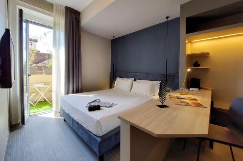 ein Hotelzimmer mit einem Bett, einem Schreibtisch und einem Fenster in der Unterkunft Vico Fashion District in Mailand