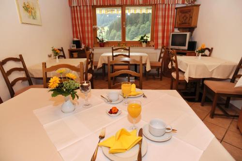ein Esszimmer mit Tischen und Stühlen sowie einem Tisch mit Speisen in der Unterkunft Haus Schönlechner in Gaschurn