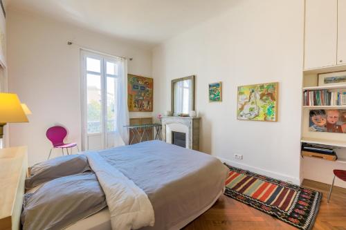 1 dormitorio con cama, escritorio y chimenea en Victor Hugo Palais AP3061 by Riviera Holiday Homes en Niza