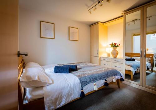 a bedroom with a bed and a dresser and a mirror at Lux Duplex Apartment 19th Century Chapel Wakefield Centre in Wakefield