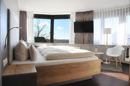 - une chambre avec un grand lit et une fenêtre dans l'établissement Am Berghang, à Bad Bentheim