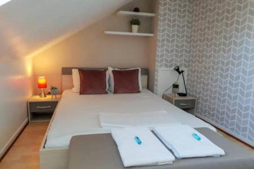 a bedroom with a large white bed with two pillows at LE DUPLEX - Hyper centre - Gare - Wifi - Duplex in Annecy