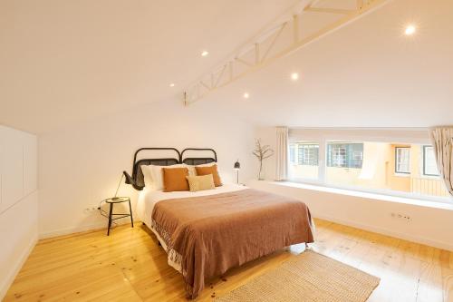 een slaapkamer met een groot bed en een raam bij The Yellow House Spacious Duplex in a Traditional Neighborhood in Lissabon