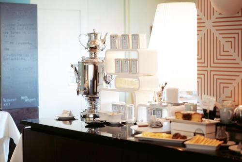 Un mostrador con una cafetera sobre una mesa con comida. en Boutiquehotel Myn Utspann, en Husum