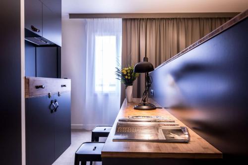 a desk with a lamp and two chairs in a room at Best Western Plus Suitcase Paris La Défense in Bois-Colombes