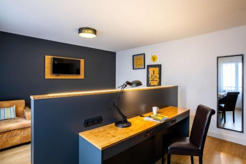a desk with a lamp and a chair in a room at Best Western Plus Suitcase Paris La Défense in Bois-Colombes