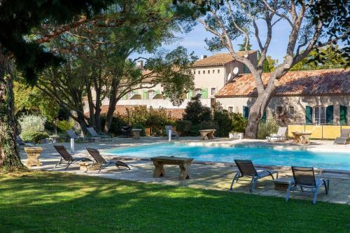 a swimming pool with chairs and a table in a yard at Best Western Le Val Majour in Fontvieille