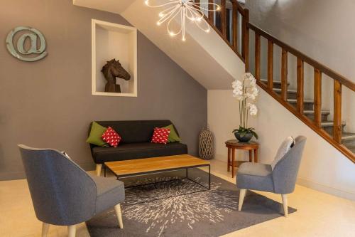 a living room with a couch and two chairs at Best Western Le Val Majour in Fontvieille