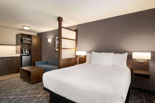 um quarto de hotel com uma cama grande e uma cozinha em Microtel Inn & Suites by Wyndham Aurora em Aurora