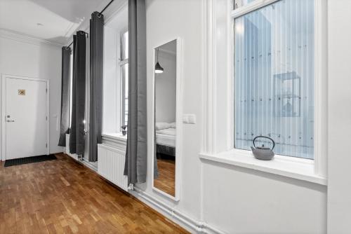 a hallway with white walls and a window and wooden floors at Sunny Central Reykjavík Apartment in Reykjavík