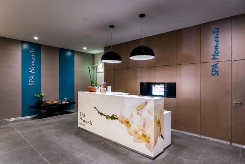 a lobby with a counter with flowers on it at Enotel Magnólia in Funchal