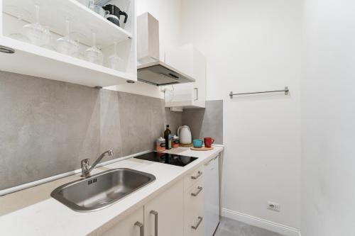 uma cozinha com armários brancos e um lavatório em FAMM Apartments - Charming and cozy Flat at Pantheon em Roma