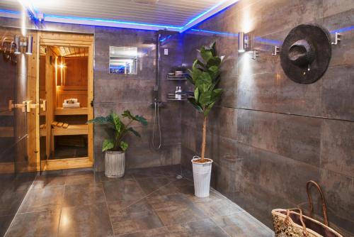 uma casa de banho com um chuveiro e uma planta em Swifts Return - Apartment with hot tub, sauna and indoor pool (Dartmoor) em Exeter