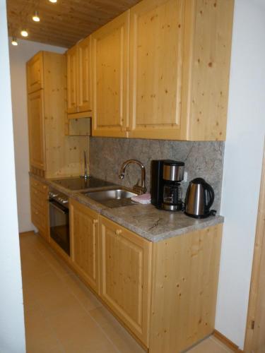 a kitchen with wooden cabinets and a sink at Apartments Teglbauernhof, Hütte, Chalet, Mobilheim, Appartement, Ferienwohnung, Pension, Urlaub in Uttendorf
