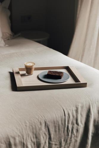 a tray with a piece of cake and a cup on a bed at Plácido y Grata in Seville