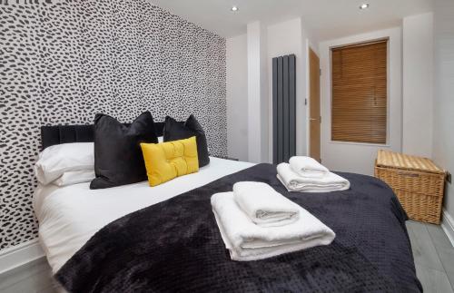 a bedroom with a large bed with towels on it at Apartment 1 The Keyes- Stylish & Spacious Apartment With Free Parking in York