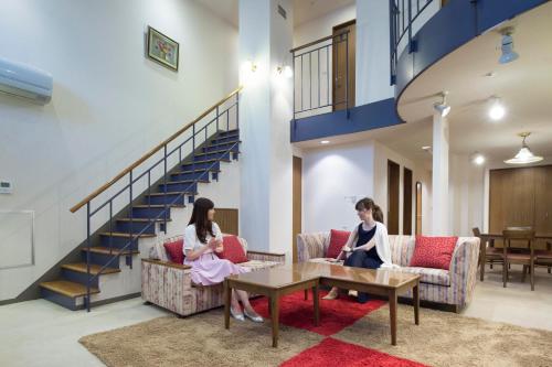 two women sitting on couches in a lobby at Izumigo AMBIENT Azumino Hotel in Azumino