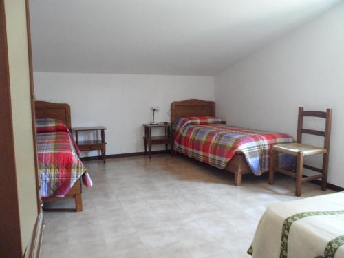 a bedroom with two beds and two tables and chairs at Case Vacanze Valdilago in Bolsena