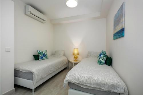 1 dormitorio con 2 camas y mesa con lámpara en FIVE STAR 3 bedroom Apt in ideal location - RDR237, en Marbella
