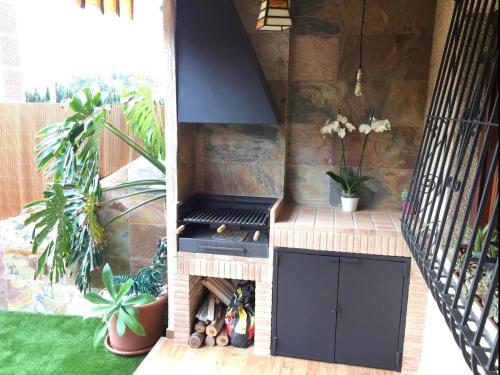 a outdoor kitchen with a stove in a backyard at BUNGALOW DE LUJO en PLAYA SAN JUAN in El Campello