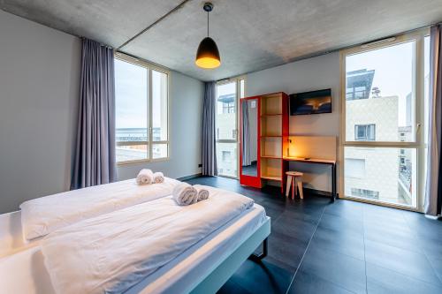 波尔多MEININGER Hotel Bordeaux Gare Saint-Jean的卧室配有一张床、一张书桌和窗户。