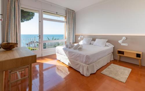 a bedroom with a bed with a view of the ocean at Villa Can Bagués in Mataró