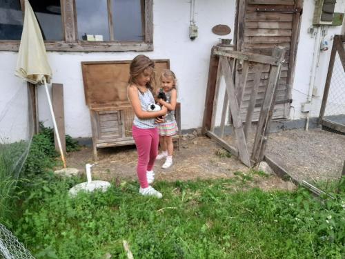 two young girls standing outside of a house at Apartments Teglbauernhof, Hütte, Chalet, Mobilheim, Appartement, Ferienwohnung, Pension, Urlaub in Uttendorf