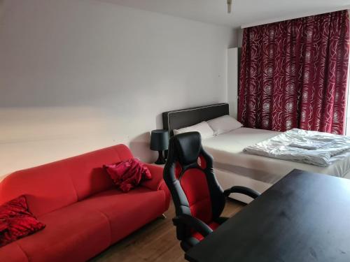 a living room with a red couch and a bed at Sehr Schöne drei Zimmer Delüx Wohnung in Sindelfingen in Sindelfingen