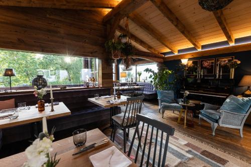 a restaurant with tables and chairs and a piano at Waldhaus Rudolfshöhe in Bad Gastein