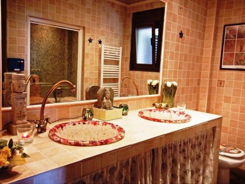 twee wastafels in een badkamer met twee kranen bij El Quinto Pino in Canillas de Albaida
