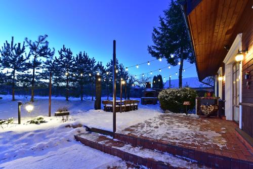 a snow covered yard with lights and a house at Spa Villa Trakai in Trakai
