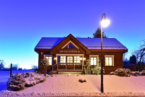 a house in the snow with a street light at Spa Villa Trakai in Trakai