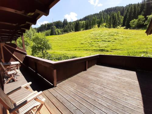 a deck with a view of a green field and trees at Apartments Teglbauernhof, Hütte, Chalet, Mobilheim, Appartement, Ferienwohnung, Pension, Urlaub in Uttendorf