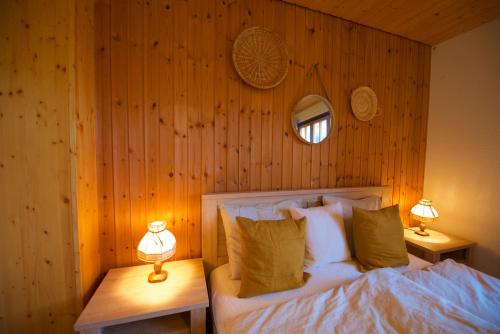 a bedroom with a bed with wooden walls and two lamps at Chalet 6 personnes avec sauna in Leysin