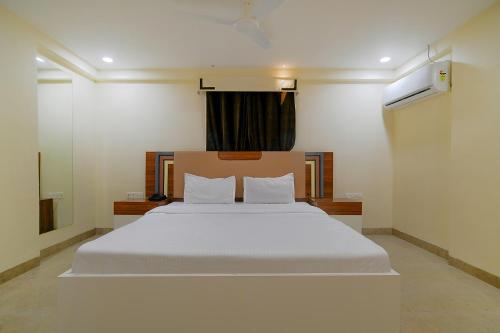 a bedroom with a large white bed with a window at FabHotel Imperial Regency in Indore
