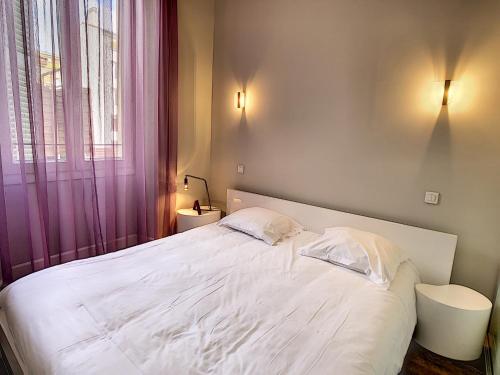 une chambre avec un lit blanc et une fenêtre dans l'établissement Le Cid 3P CIR3374, à Cannes