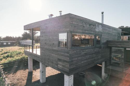a small wooden house sitting on stands in a field at Morros del Pacífico in Pichilemu
